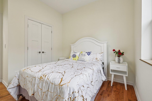 bedroom featuring wood finished floors, a closet, and baseboards