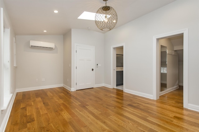 interior space with recessed lighting, light wood-style flooring, a wall mounted air conditioner, and baseboards