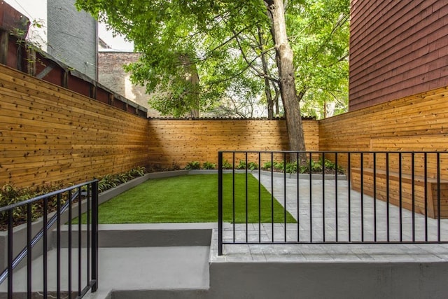 view of gate with a yard and fence