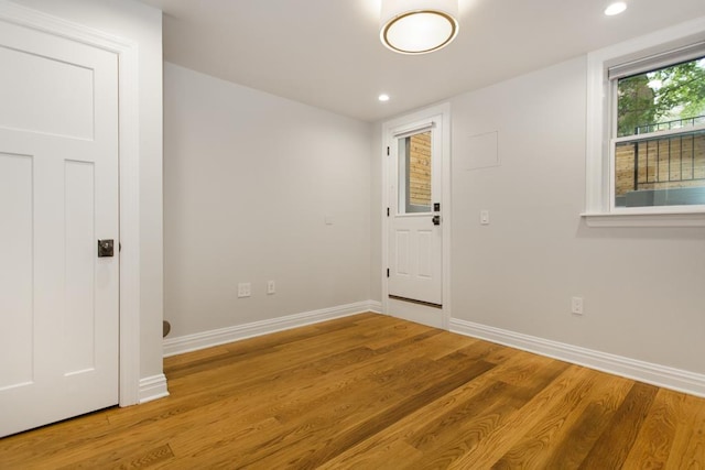 unfurnished room with recessed lighting, wood finished floors, and baseboards