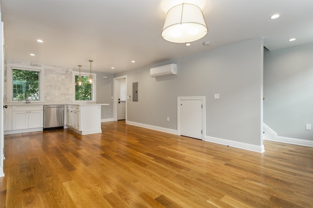 interior space with electric panel, light wood finished floors, recessed lighting, and a wall unit AC