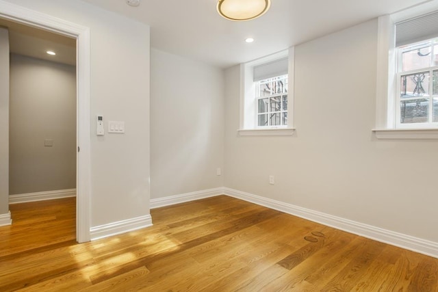 empty room featuring recessed lighting, baseboards, and wood finished floors