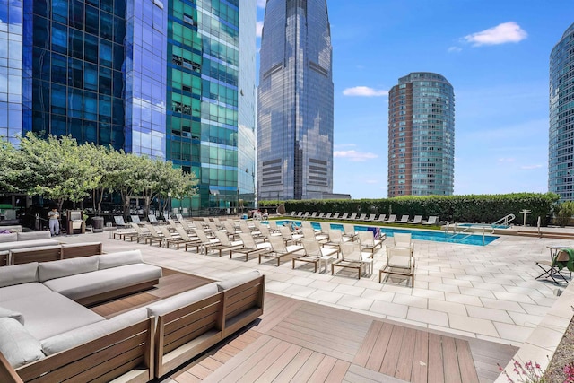 community pool featuring outdoor lounge area, a city view, and a patio area