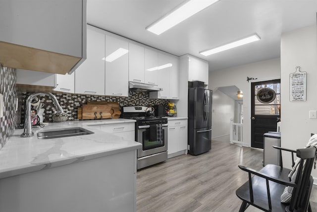 4319 Cottage Ave, North Bergen, NJ 07047 - kitchen with stainless steel gas range, under cabinet range hood, freestanding refrigerator, white cabinets, and backsplash