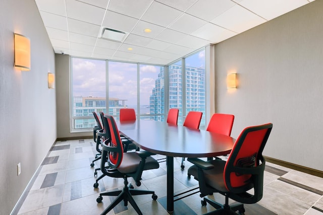 dining area with a healthy amount of sunlight, expansive windows, baseboards, and a city view