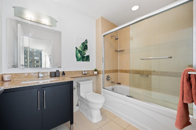 bathroom with bath / shower combo with glass door, vanity, tile patterned flooring, and toilet