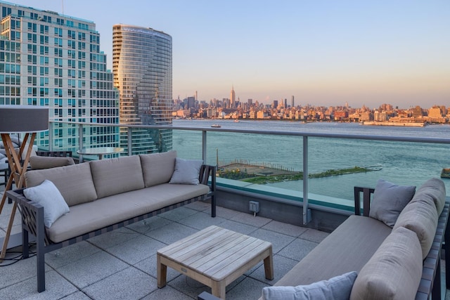 balcony with a water view, outdoor lounge area, and a city view