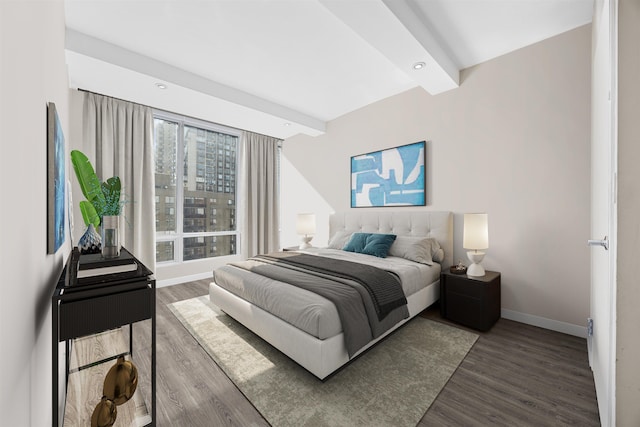 bedroom with baseboards, beamed ceiling, and wood finished floors