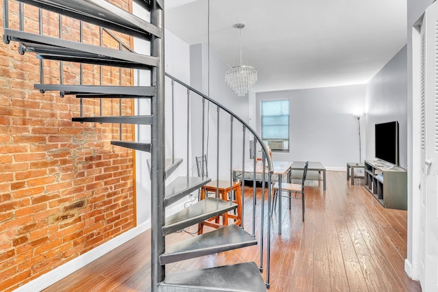294 Barrow St Unit 6, Jersey City, NJ 07302 - staircase with hardwood / wood-style flooring, a chandelier, brick wall, and cooling unit