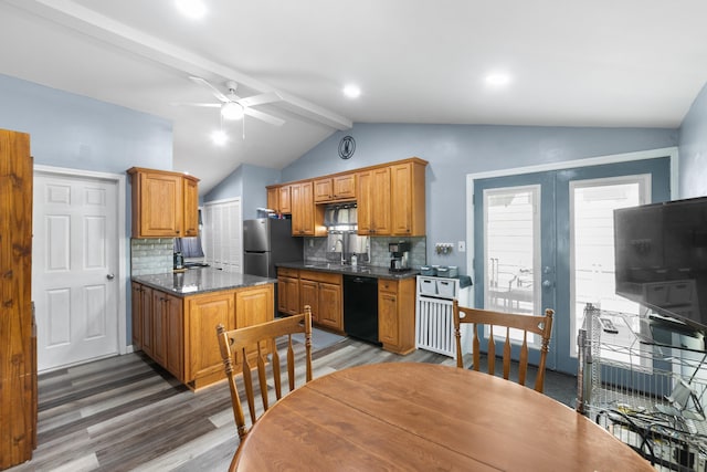 kitchen featuring lofted ceiling with beams, black dishwasher, light wood-type flooring, and backsplash