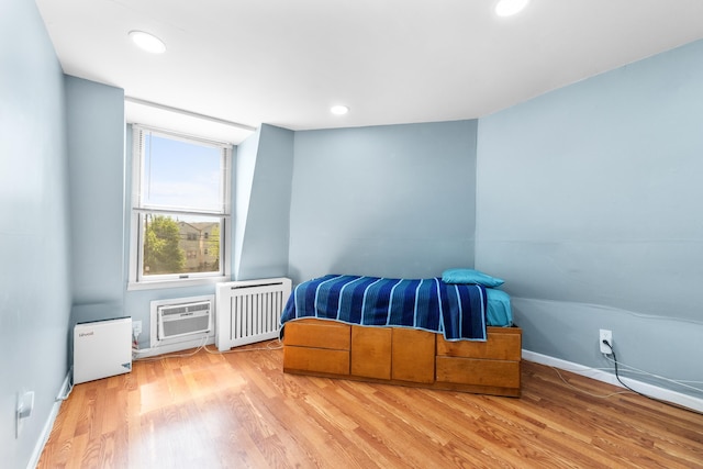 bedroom featuring recessed lighting, radiator, light wood finished floors, and baseboards