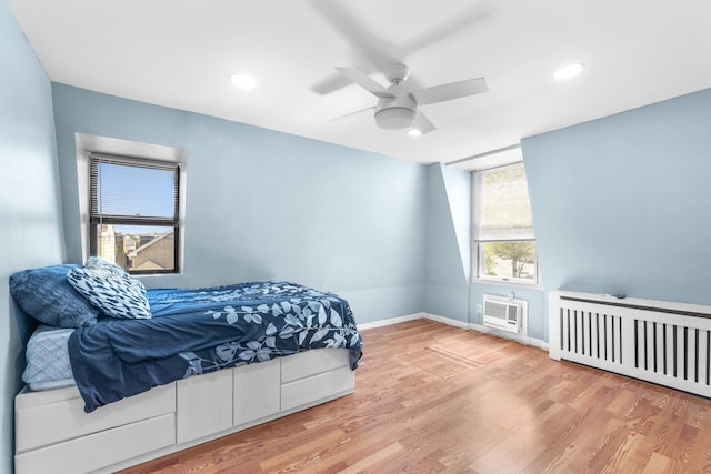 bedroom with radiator, a ceiling fan, baseboards, recessed lighting, and wood finished floors