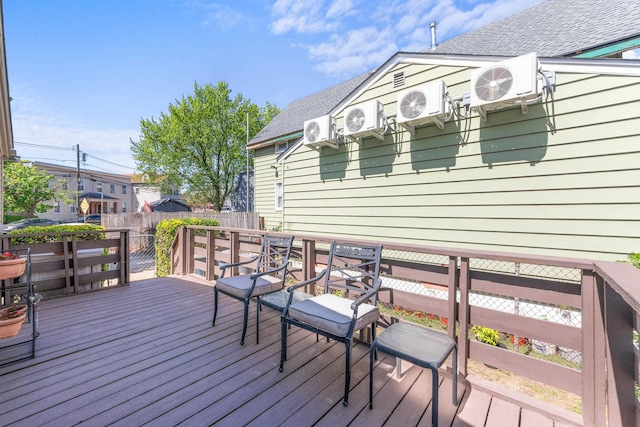 wooden deck featuring fence, ac unit, and outdoor dining area
