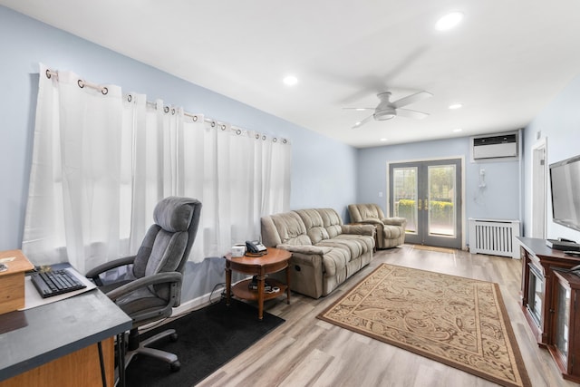 office area featuring ceiling fan, french doors, a wall mounted air conditioner, light wood finished floors, and radiator heating unit