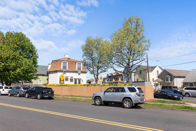 view of street with curbs, traffic signs, sidewalks, and a residential view