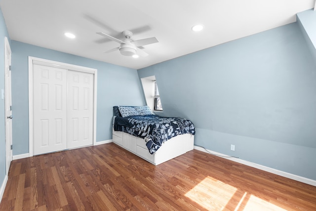 bedroom with recessed lighting, baseboards, wood finished floors, and a closet