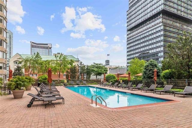 pool featuring fence and a patio area