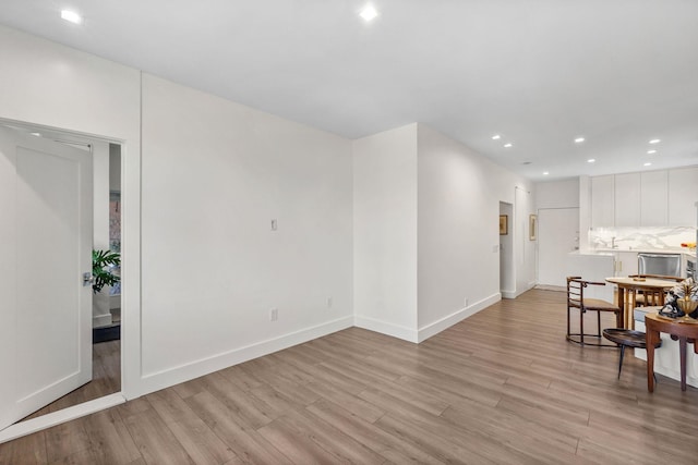 dining space featuring baseboards, light wood-type flooring, and recessed lighting