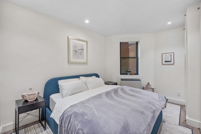 bedroom with baseboards, wood finished floors, and recessed lighting