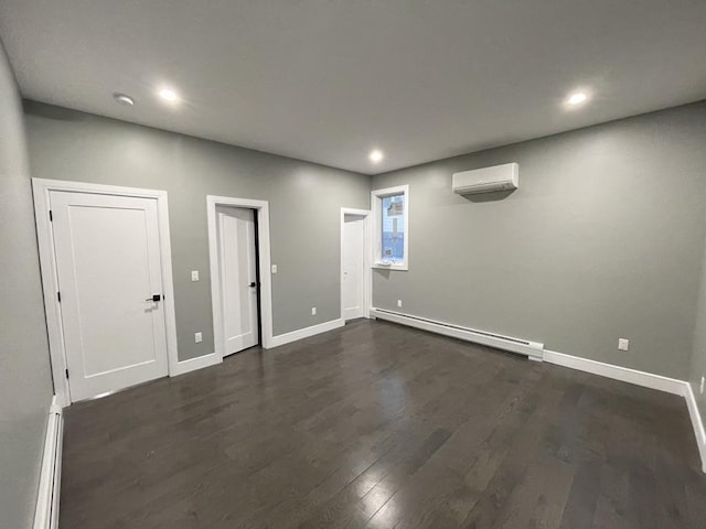 basement with recessed lighting, a wall mounted AC, dark wood-style floors, baseboard heating, and baseboards