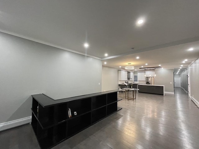 interior space featuring recessed lighting, a center island, baseboards, stainless steel refrigerator with ice dispenser, and white cabinets