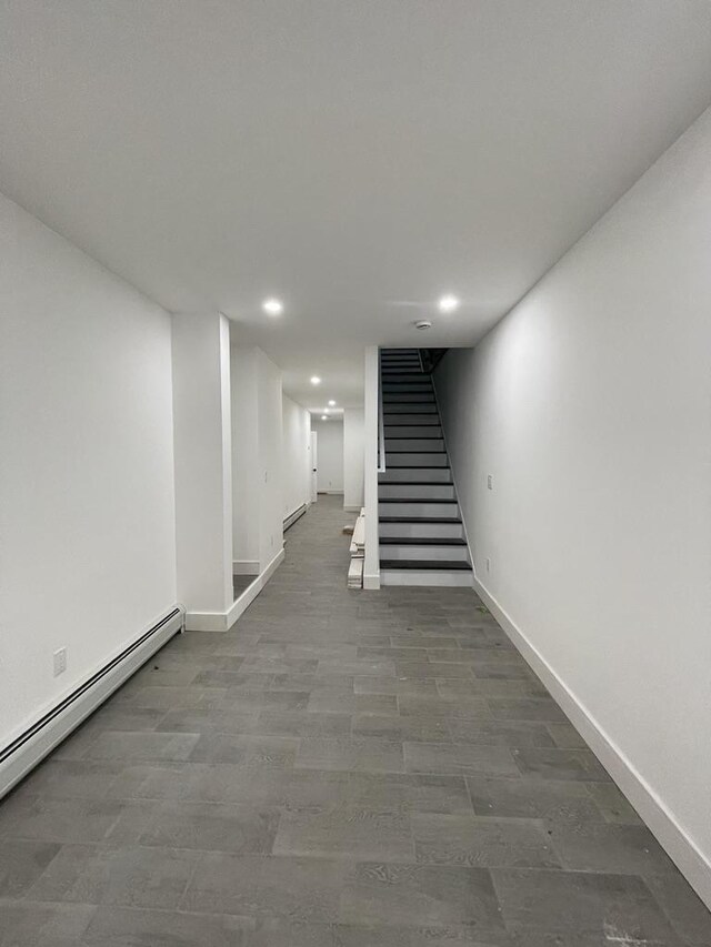 hallway with baseboards, stairway, baseboard heating, and recessed lighting