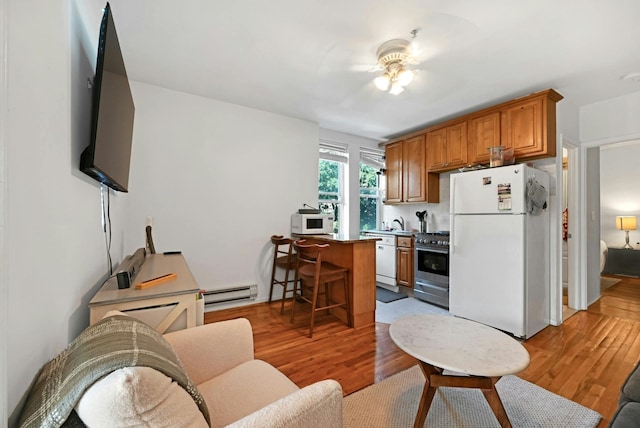 734 Adams St Unit 4B, Hoboken, NJ 07030 - living area with a baseboard radiator and light wood-style floors