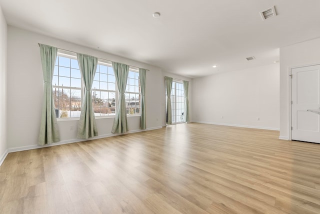 spare room featuring light wood-style floors and baseboards