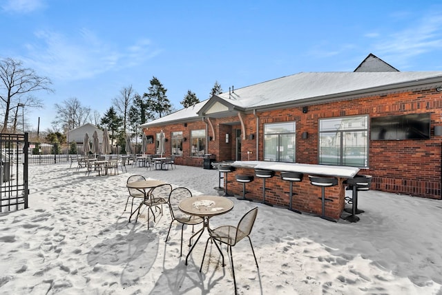 snow covered patio featuring fence