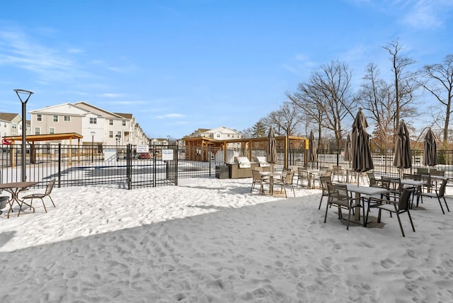 yard layered in snow with fence and a residential view