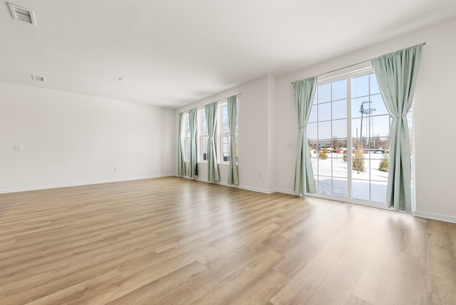 spare room featuring light wood-style flooring and baseboards
