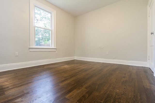 unfurnished room featuring dark wood-type flooring and lofted ceiling