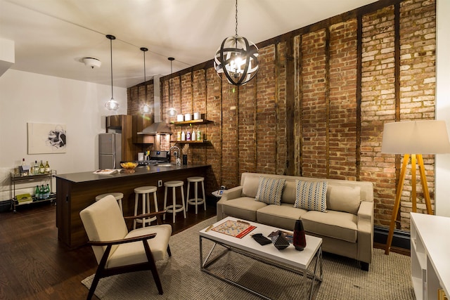 bar with wall chimney range hood, hanging light fixtures, stainless steel refrigerator, and dark hardwood / wood-style floors