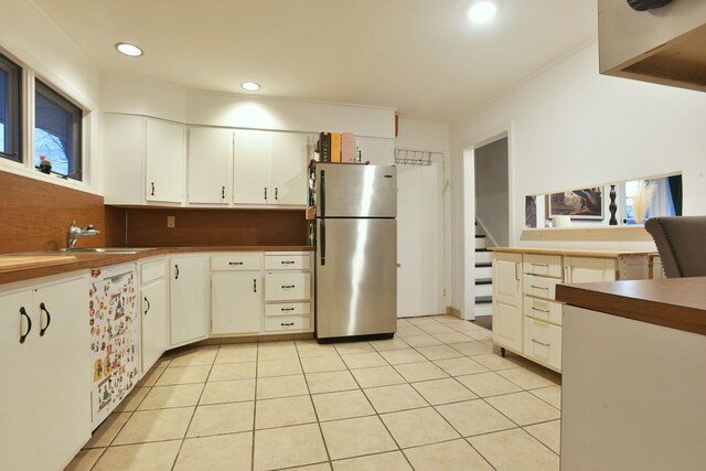 87 Stony Ridge Dr, Hillsdale, NJ 07642 - kitchen with light tile patterned floors, white cabinets, a sink, and freestanding refrigerator