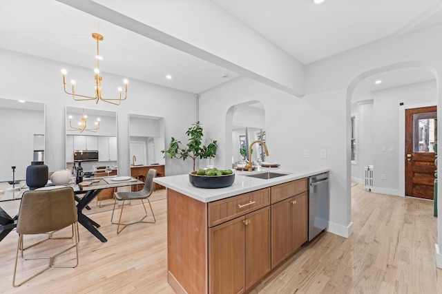 kitchen with sink, an inviting chandelier, decorative light fixtures, light hardwood / wood-style flooring, and dishwasher