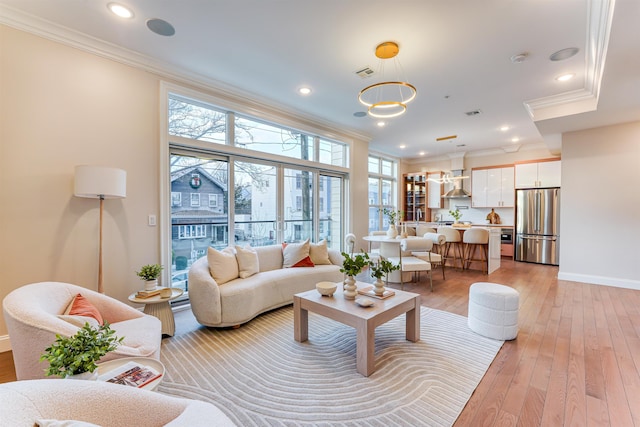 living room with ornamental molding and light hardwood / wood-style flooring