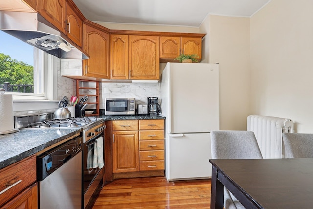 5 77th St, North Bergen, NJ 07047 - kitchen with radiator heating unit, appliances with stainless steel finishes, dark countertops, under cabinet range hood, and crown molding