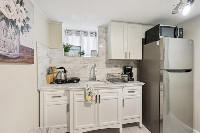 5 77th St, North Bergen, NJ 07047 - kitchen featuring freestanding refrigerator, tasteful backsplash, white cabinetry, light stone counters, and light tile patterned floors