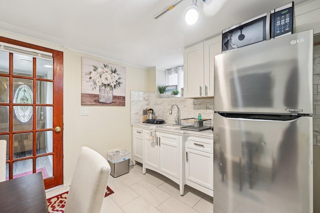 5 77th St, North Bergen, NJ 07047 - kitchen featuring freestanding refrigerator, light tile patterned floors, tasteful backsplash, white cabinetry, and light stone countertops