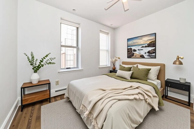 297 Pavonia Ave Unit 2A, Jersey City, NJ 07302 - bedroom with baseboard heating, dark wood-style floors, ceiling fan, and baseboards
