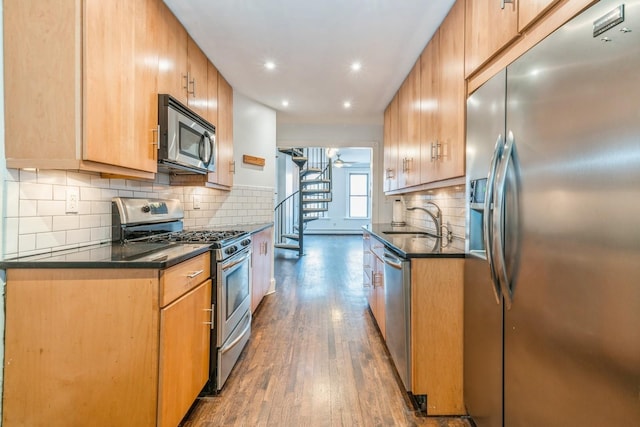 297 Pavonia Ave Unit 2A, Jersey City, NJ 07302 - kitchen featuring stainless steel appliances, a sink, dark countertops, dark wood-type flooring, and decorative backsplash