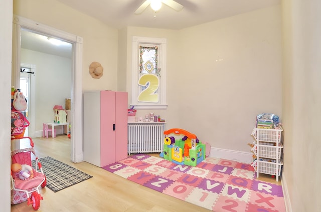 400 67th St, West New York, NJ 07093 - playroom featuring radiator heating unit, ceiling fan, and wood finished floors