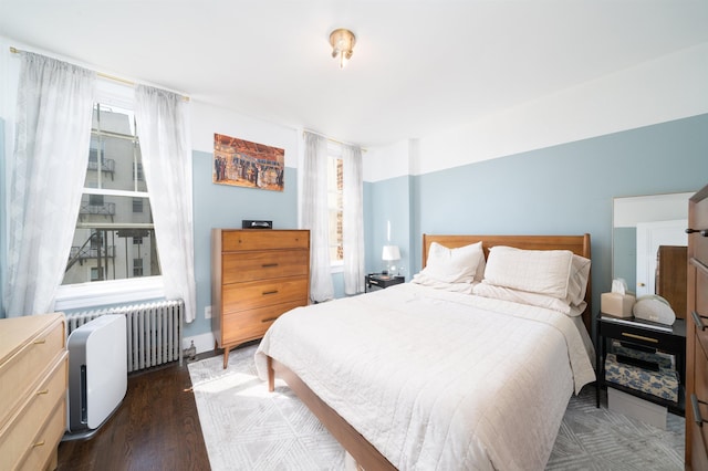 bedroom featuring wood finished floors and radiator heating unit