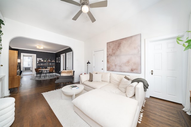 living area featuring arched walkways, ceiling fan, wood finished floors, and vaulted ceiling