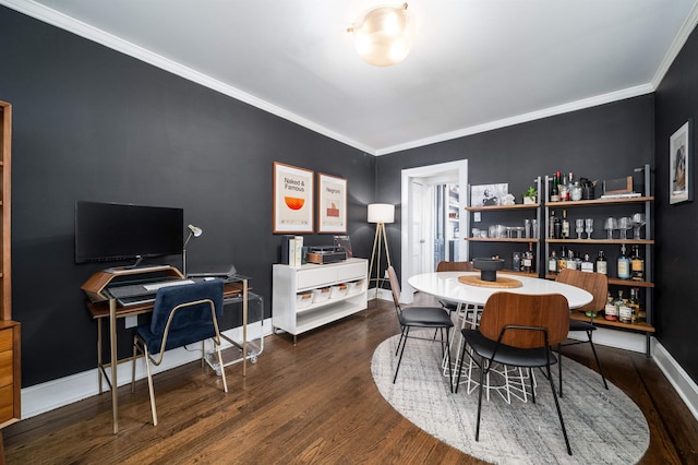 dining area featuring crown molding, baseboards, and wood finished floors