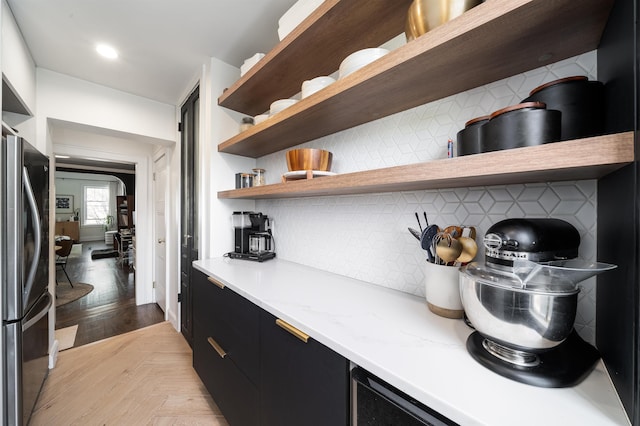 bar featuring freestanding refrigerator, backsplash, and recessed lighting