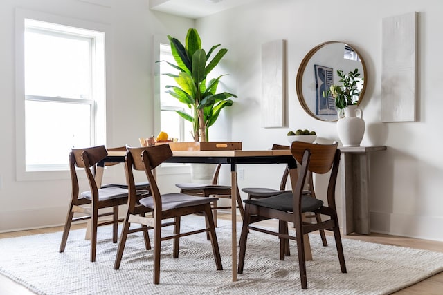 dining area with baseboards and wood finished floors