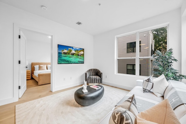 sitting room with visible vents, baseboards, and light wood-style floors