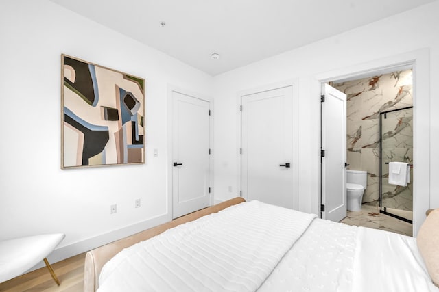 bedroom with baseboards and ensuite bath