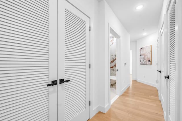 hall featuring recessed lighting, baseboards, and light wood-style floors